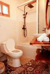 a bathroom with a toilet and a bath tub at Sababa Resort in San Pedro La Laguna +22 photos