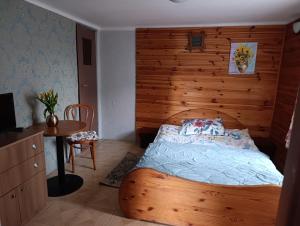 a bedroom with a bed with a wooden wall at Agroturystyka Wypoczynek na Wsi in Słowiki Nowe