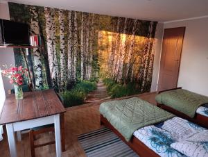 a bedroom with a wall mural of a forest at Agroturystyka Wypoczynek na Wsi in Słowiki Nowe