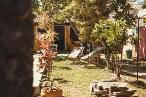 a garden with two chairs and a house at Chill House Buzios in Búzios