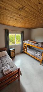 a bedroom with two bunk beds and a window at Hostel Aonikenk in El Calafate