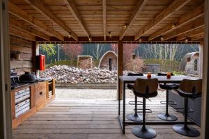 a kitchen with a table and chairs on a patio at Studio with Pool Table and Optional Sauna & Hot Tub in Zwaanshoek
