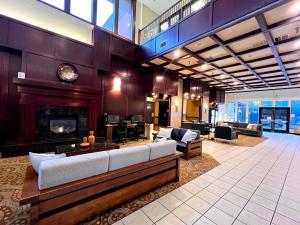 a lobby with a fireplace and furniture in a building at Ramada by Wyndham Tukwila Southcenter in Tukwila