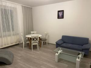 a living room with a blue couch and a table at Jak w domu in Słupsk