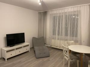 a living room with a television and a table at Jak w domu in Słupsk