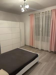 a bedroom with a bed and pink curtains at Jak w domu in Słupsk