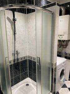a shower with a glass door in a bathroom at Jak w domu in Słupsk
