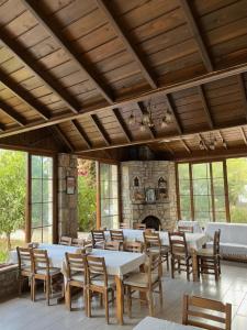 a dining room with tables and chairs and a fireplace at Melinda Pension & Restaurant in Mesudiye