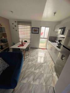 a living room with a table and a kitchen at Mi Casa Modernista cerca del AIFA in Santa Cruz Tecamac