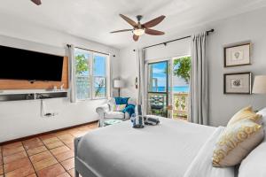 a bedroom with a bed and a flat screen tv at Tres Sirenas Beach Inn in Rincon