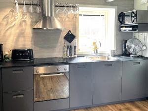 a kitchen with stainless steel appliances and a sink at 4 star holiday home in SÖLVESBORG in Sölvesborg