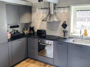 a kitchen with stainless steel appliances and a sink at 4 star holiday home in SÖLVESBORG in Sölvesborg