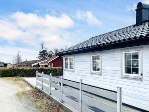 a white house with a fence in front of it at 4 star holiday home in SÖLVESBORG in Sölvesborg +22 photos