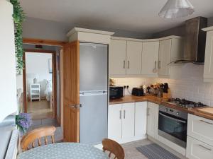 a kitchen with white cabinets and a table at Teach Barney in Falcarragh