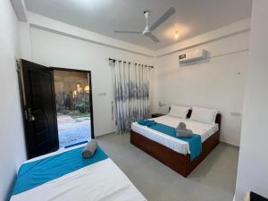 a bedroom with two beds and a window at LA PRINCE HOTEL and HOSTEL in Trincomalee