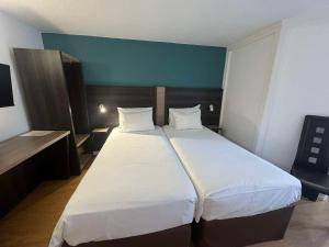 a bedroom with a large bed with white sheets at Hôtel Kyriad Epernay en Champagne in Épernay