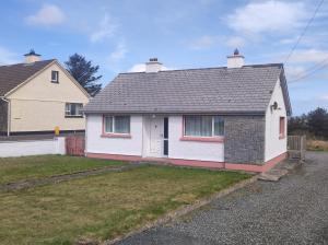 a white house with a black roof at Teach Barney in Falcarragh