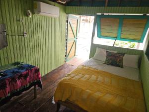 a bedroom with a bed in a green room at Tio Toms Guesthouse in Bastimentos