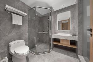 a bathroom with a shower and a toilet and a sink at 夏朗酒店 Xialang Hotel&Free ShuttleBus to Guangzhou BaiyunInternational Airpor in Guangzhou +47 photos