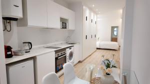 a kitchen with white cabinets and a table with chairs at The Eight Element Suites & Lofts in Madrid +98 photos