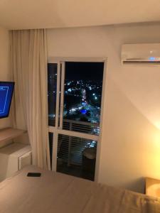 a bedroom with a view of a city at night at Aparthotel diamond flat in Nova Iguaçu +21 photos
