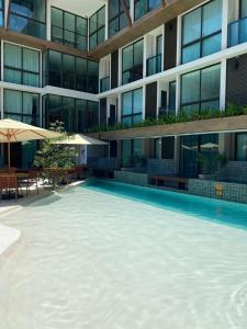 a large swimming pool in front of a building at Sunny Hall Porto de Galinhas PE - Flat Piscina Privativa in Porto De Galinhas