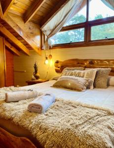 a large bed in a room with a large window at Tierras del Sur II in Villa La Angostura