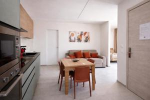 a kitchen and living room with a table and a couch at Davs Home Appartamento per 4 a Lentini con WiFi Self Check in in Lentini