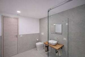 a bathroom with a toilet and a glass shower at Davs Home Appartamento per 4 a Lentini con WiFi Self Check in in Lentini