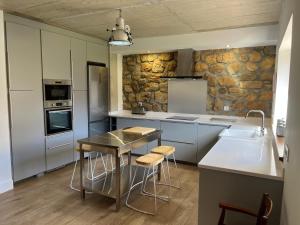 a kitchen with a table and stools in it at La casa de Cabuérniga in Cabuerniga