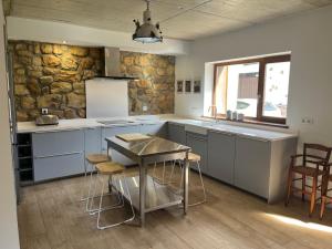 a kitchen with a table and a stone wall at La casa de Cabuérniga in Cabuerniga