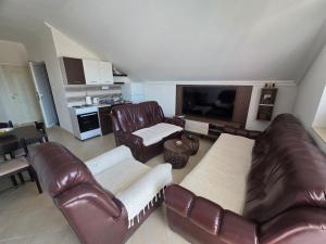 a living room with leather furniture and a television at Jovanovic Apartment in Tivat