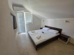 a bedroom with a bed with white sheets and pillows at Jovanovic Apartment in Tivat