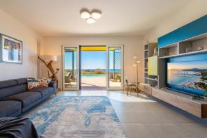 a living room with a large flat screen tv at Luxury Sunshine Villa in Alghero with pool and sea view in Alghero