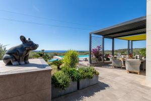 a statue of a dog sitting on a patio at Luxury Sunshine Villa in Alghero with pool and sea view in Alghero