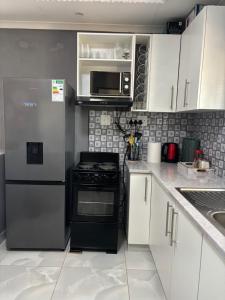 a kitchen with a refrigerator and a microwave at The Valley View Nest in Ezulwini