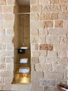 a brick wall with a shelf in a bathroom with towels at Petra dimora leccese in Lecce +63 photos