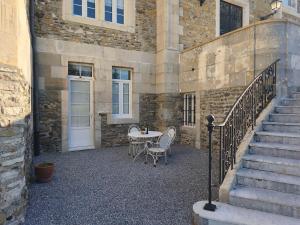 a patio with a table and chairs next to a building at ChâtEscos - Estudio en Château in Escos