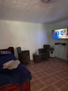 a bedroom with a bed and a flat screen tv at Villa Luis in Boquete