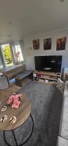 a living room with a table with roses on it at Sunny Haven in Skegness