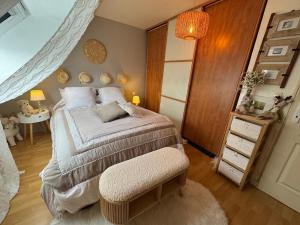 a bedroom with a bed with a chair and a table at Au Bois Dormant in Monterblanc