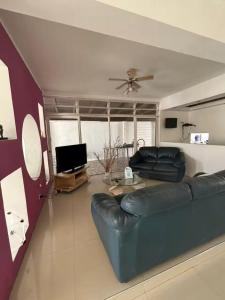a living room with a blue couch and a tv at La Milagrosa in Caracas