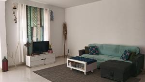 a living room with a couch and a tv at Ka'Zinha Guesthouse - Chambres d'hôtes Tarrafal in Tarrafal