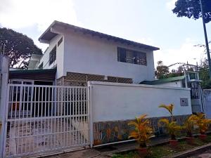 a white house with a gate and a fence at La Milagrosa in Caracas