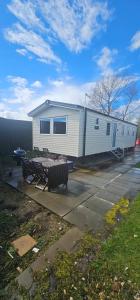 a house with a picnic table and a trailer at Sunny Haven in Skegness