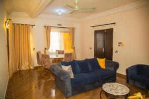 a living room with a blue couch and a table at Sika Résidence Bénin in Cocotomey