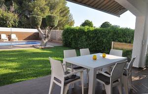 a white table and chairs on a patio at Roda Bruc, casa con piscina privada! in Roda de Bará