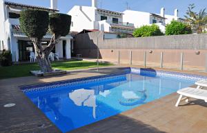 a blue swimming pool with a tree in the middle at Roda Bruc, casa con piscina privada! in Roda de Bará
