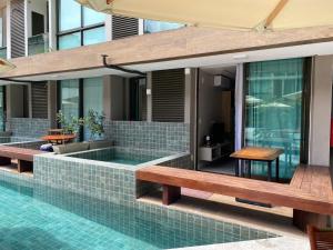 a swimming pool with benches next to a building at Sunny Hall Porto de Galinhas PE - Flat Piscina Privativa in Porto De Galinhas