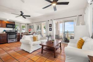 a living room with two white couches and a table at Tres Sirenas Beach Inn in Rincon